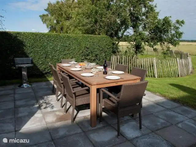 Hof Statendijk | Pays-Bas, Zélande, IJzendijke - ferme Terrasse avec grande table en teck et chaises en osier et barbecue. Derrière la terrasse, vous pouvez voir la clôture avec l'étang.
Il y a aussi un foyer pour se chauffer les soirées fraîches.
Il y a une petite table similaire dans la buanderie à rejoindre (si vous êtes à plus de 8 personnes)