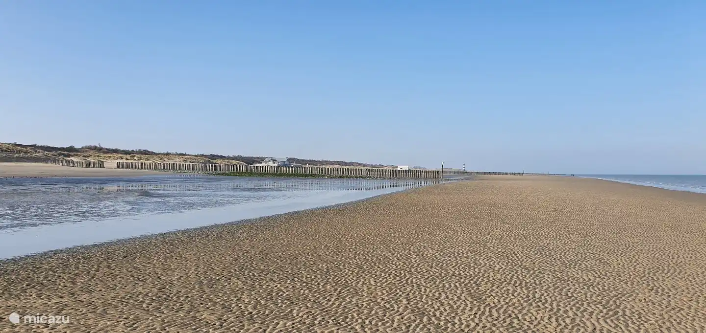 Breskens, plage à marée basse. Vue sur les pavillons de plage Halve Maentje et Loods 10 et plus loin sur le phare.