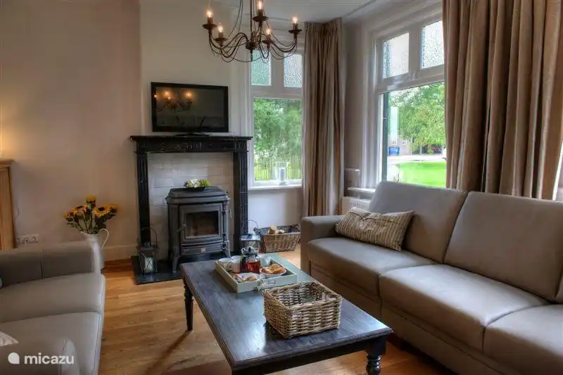 une autre vue du coin salon dans le salon. Foyer en marbre avec poêle à bois et un téléviseur au-dessus (télé interactive via internet)