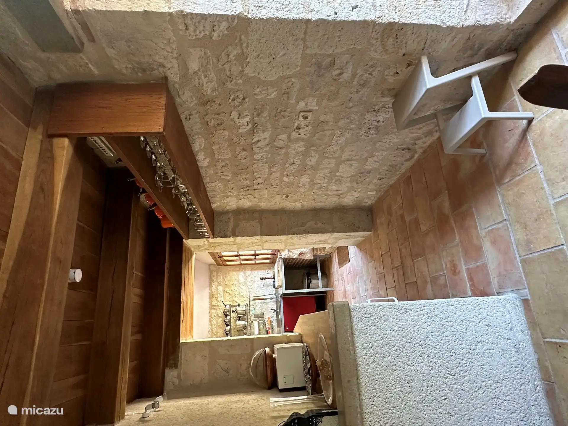 Doorgang tussen eetdeel en keuken met links een diepriezer en de wasmachine.
Passage entre table à manger et cuisine avec à gauche la machine à laver et le congélateur