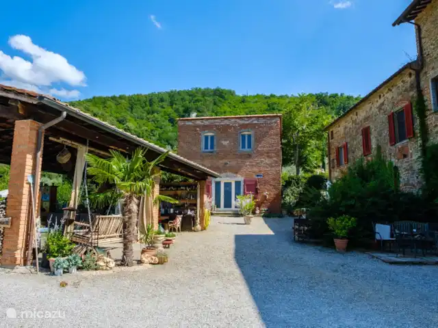 Casale le Colonne, Il Tramonto en Italia, Toscana, Castiglion Fiorentino - casa vacacional Patio fotográfico con el general Capanna a la izquierda, donde todos pueden sentarse juntos para una barbacoa o cenar.