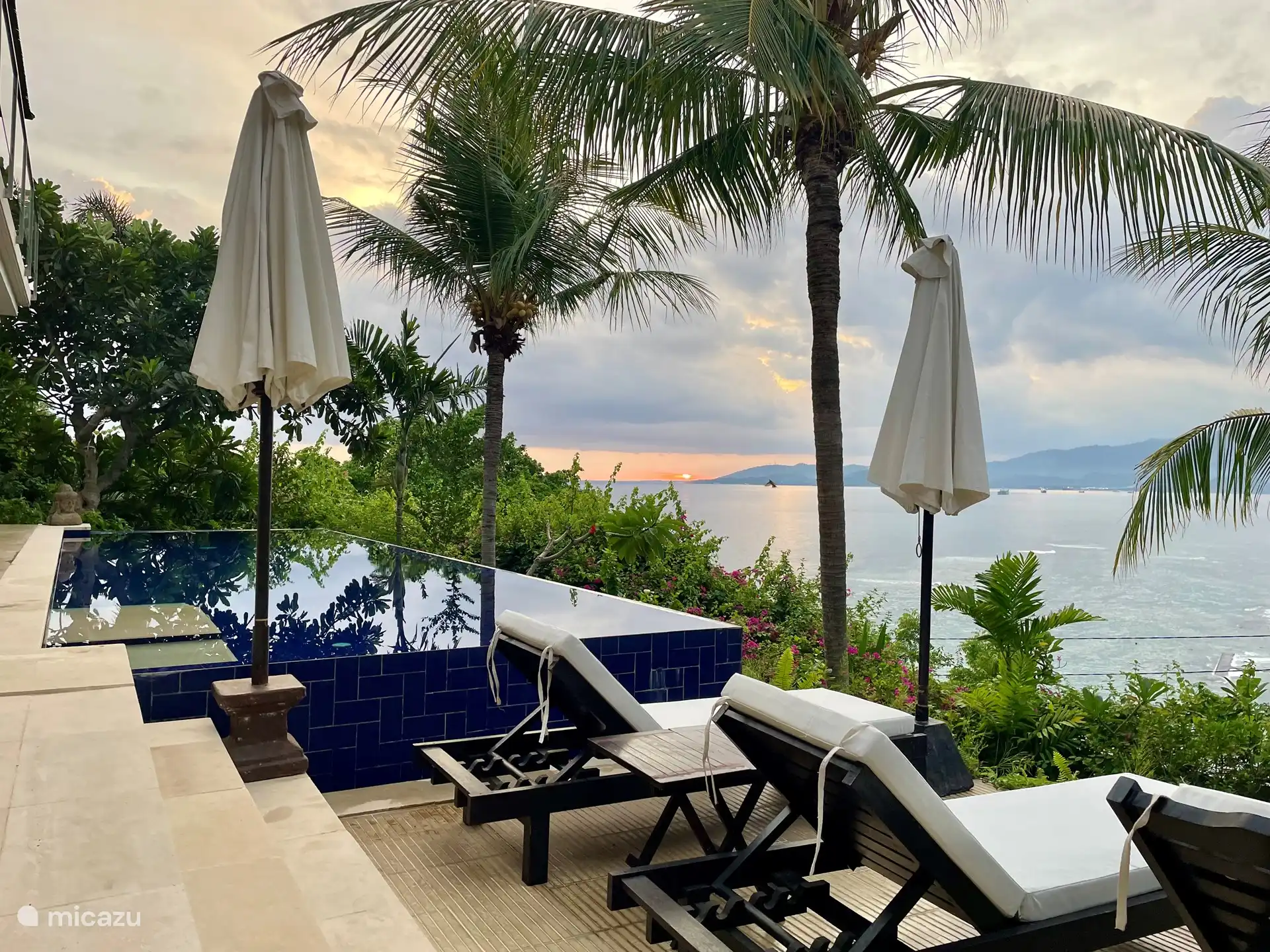 The swimming pool with sunbeds and parasols