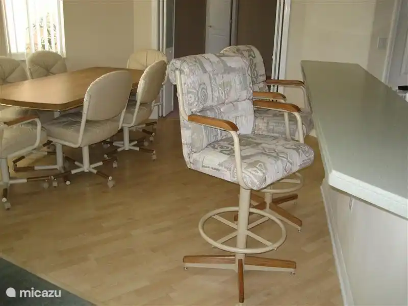 De ontbijthoek en de keukenbar met 2 luxe krukken