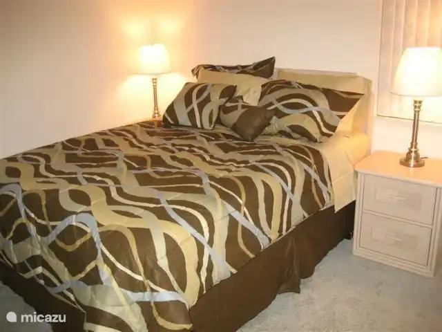 villa huren in Verenigde Staten, Florida, Spring Hill – Villa met zwembad in Spring Hill Slaapkamer aan de linkerkant van het huis met queensizebed en meubel met grote spiegel. 
Slaapkamer heeft ingebouwde kledingkast.