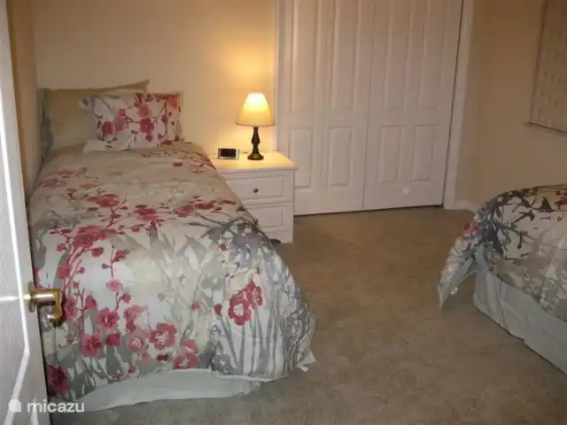villa huren in Verenigde Staten, Florida, Spring Hill – Villa met zwembad in Spring Hill Tweede slaapkamer aan de linkerkant van het huis met 2 1-persoonsbedden en nachtkastjes. De ingebouwde kledingkast is op de foto zichtbaar. Deze kamer deelt samen met de hierboven genoemde slaapkamer de badkamer met ligbad en toilet.