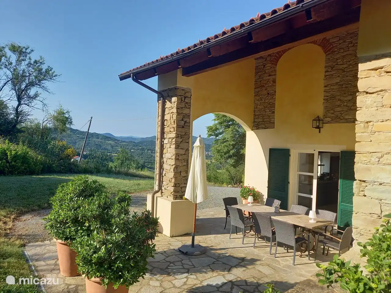En el pórtico (terraza parcialmente cubierta) una gran mesa de comedor para ocho personas. Por la tarde un lugar sombreado.