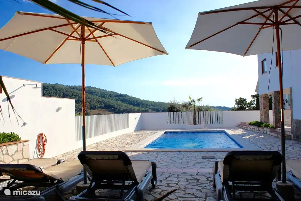 Vue sur les collines verdoyantes et la mer.
