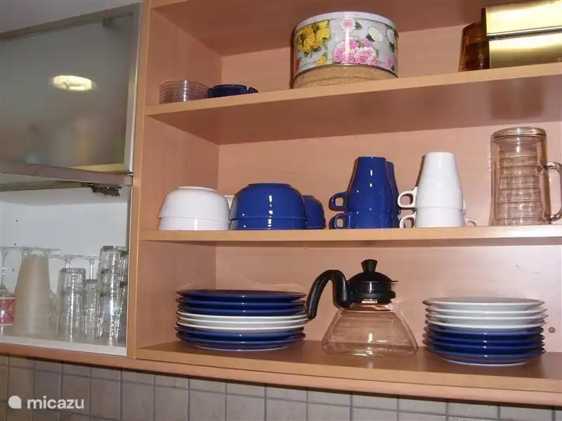 Hängeschränke in der Küche mit viel Glas und Keramik Geschirr