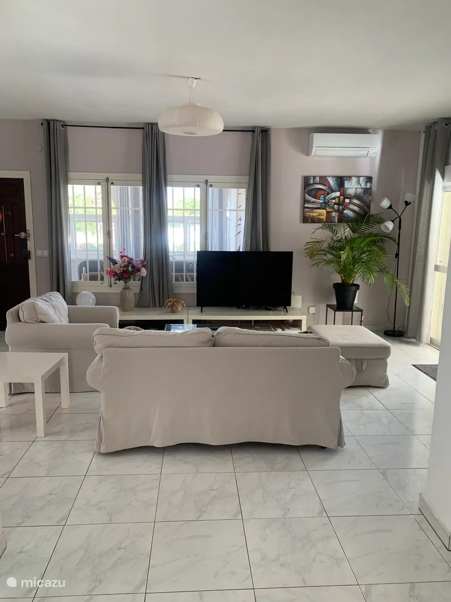 De huiskamer vanaf de keuken. Met grote tv