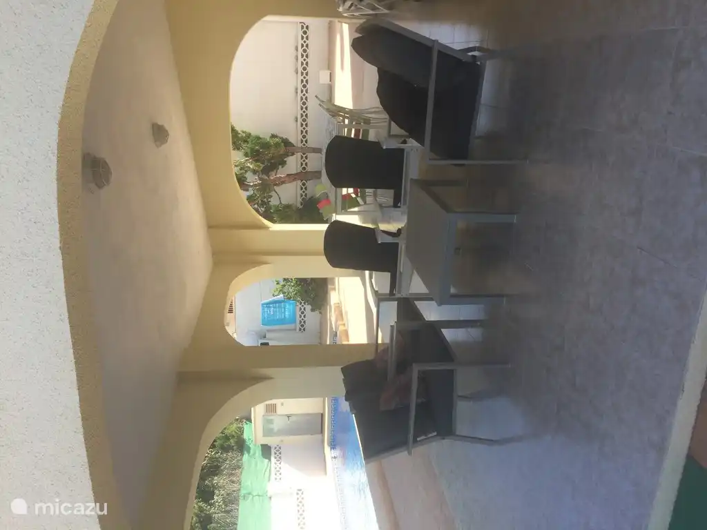 La terraza cubierta con mesa de comedor con 6 sillas y un juego de jardín y 2 tumbonas