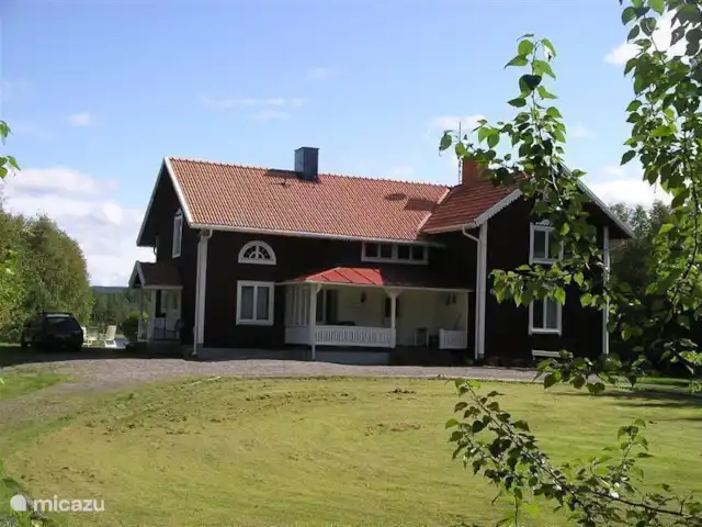 Alvsjo Herrgarden | Suède, Värmland, Filipstad - ferme Le Herrgarden de face en venant du village. Le long de l'entrée de la cuisine, un aperçu du lac derrière elle.