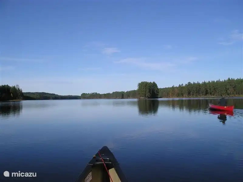 Der große See ist wie ein Spiegel an einem Abend Kanufahrt vom Dorf