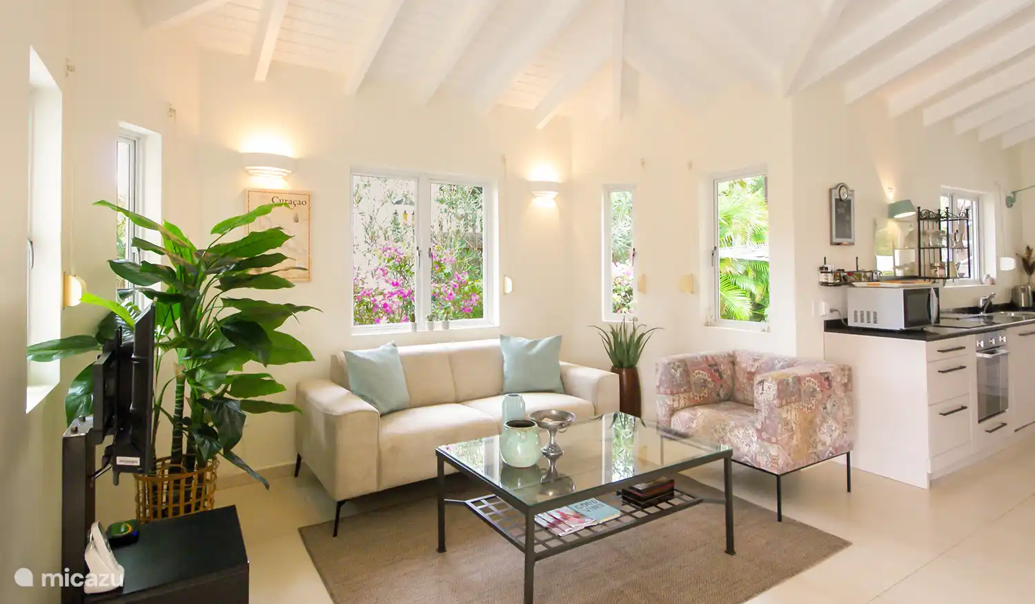 Le spacieux salon-salle à manger est meublé d’un coin salon, d’une table à manger spacieuse et d’une cuisine moderne