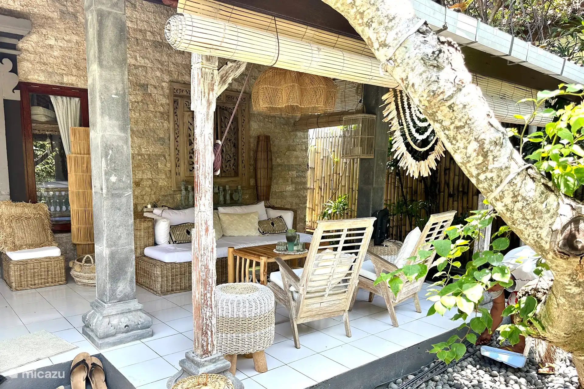 Die Veranda mit schönem, geräumigem Sitz-/Loungesofa mit Deckenventilator. Von hier aus kommst du nicht weg. Blick auf den Teich mit Pergola aus Bambus mit wunderschönen Lilla-Hängeblumen, die wie Orchideen aussehen.