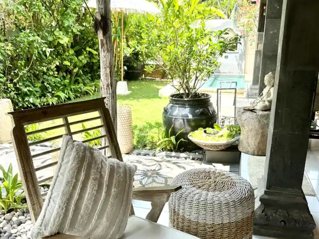 Villa Rumah Pantai No.14 huren in Indonesië, Bali, Jasri - villa Het zithoekje tegenover de loungebank. Hier heb je uitzicht over de vijver en de leuke bamboe pergola met prachtige lila hangbloemen die op orchideen lijken.
