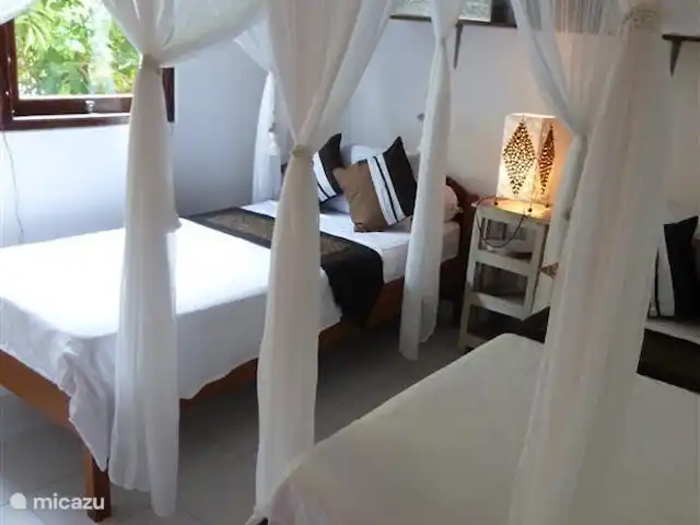 Villa Rumah Pantai No.14 huren in Indonesië, Bali, Jasri - villa De 2e slaapkamer met 2 losse bedden, in ook weer een mooie luxe Balinese hotelsfeer. Ook hier is een airco aanwezig. Verder een grote kledingkast, mooie handgesneden teakhouten sidetable en liggen de strandlakens voor u klaar.