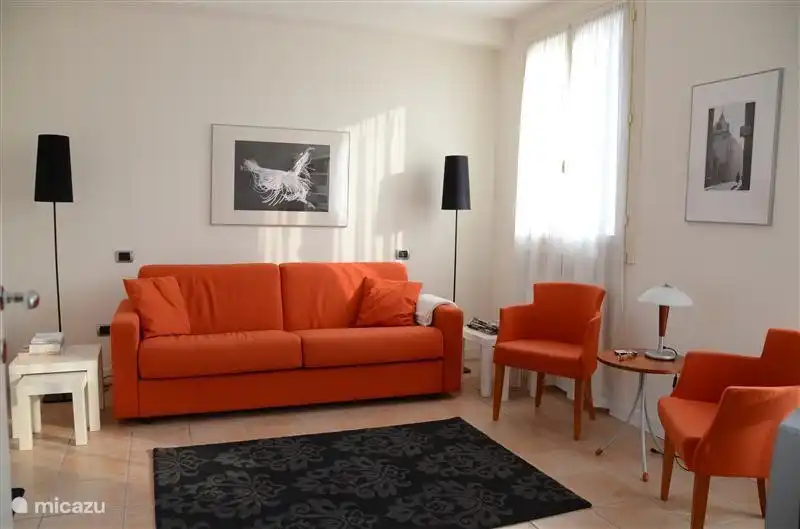 La sala de estar con piso de piedra y muebles frescos. Justo la ventana del lado de la calle. El sofá es una cómoda cama doble en poco tiempo.