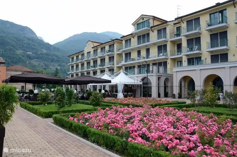 El frente del Palazzo, con bar Pannama, restaurante Ostaria del Porto, una gran terraza y tiendas. La piscina también se encuentra entre el Palazzo y el lago.
