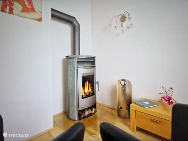 Haus-Myrte | Autriche, Salzburgerland, Flachau - appartement Le foyer au salon, le bois à brûler est inclus. Il y a aussi deux chaises supplémentaires.