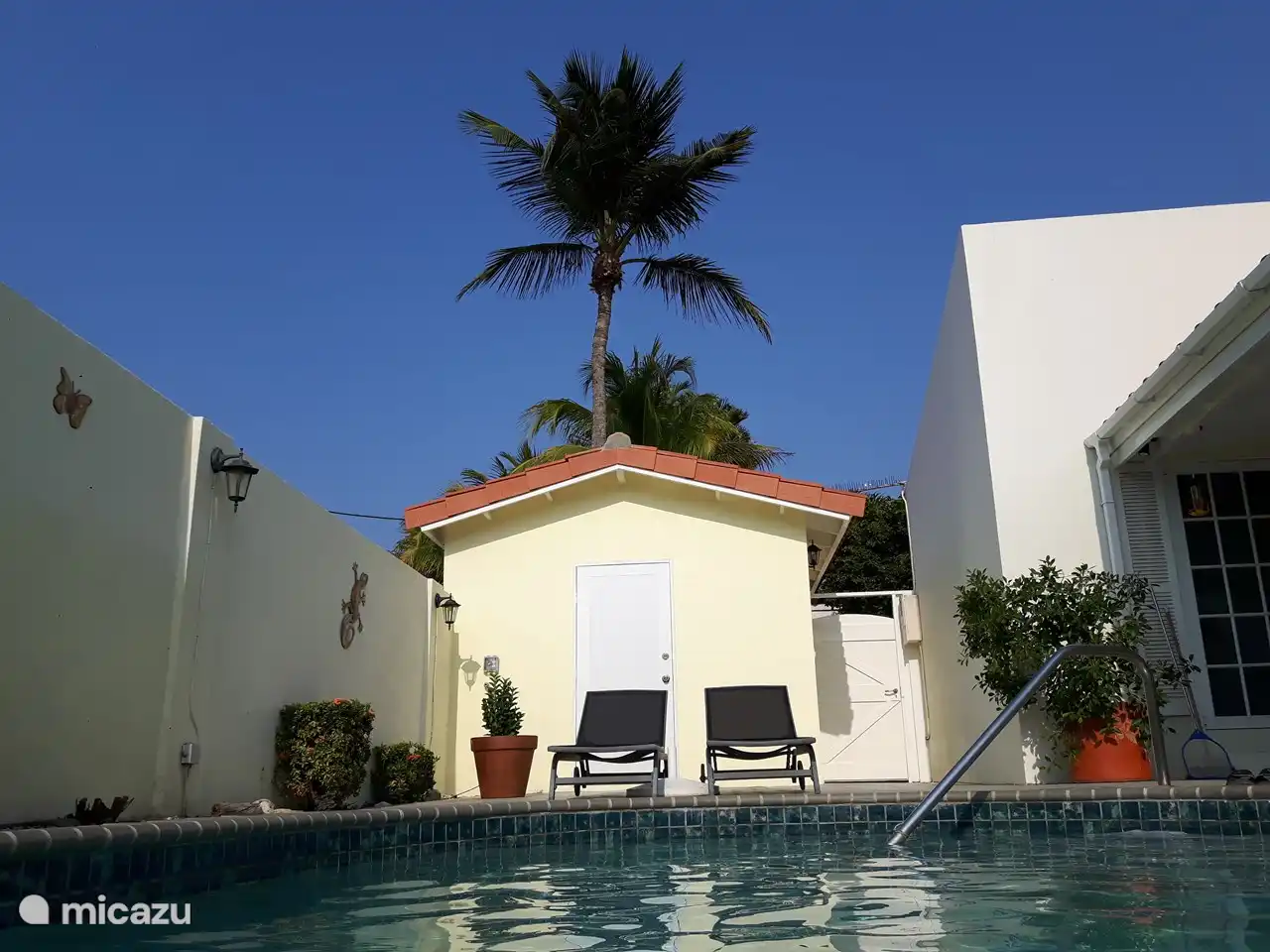 Der Schuppen mit zusätzlichen Sonnenliegen, Grill und Kinderspielzeug. Hinten der Waschraum mit Waschmaschine und Trockner.