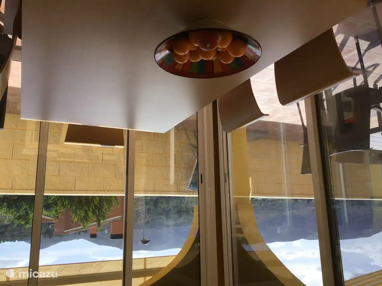 A conservatory where you can relax, overlooking the terrace with swimming pool and the mountains.