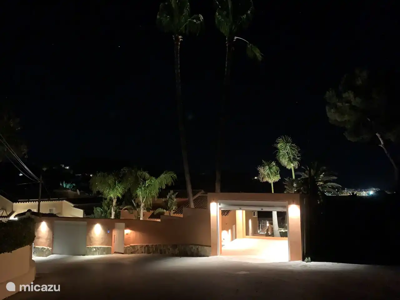 Zicht op voorzijde huis in de avond met op de achtergrond het centrum van Moraira.