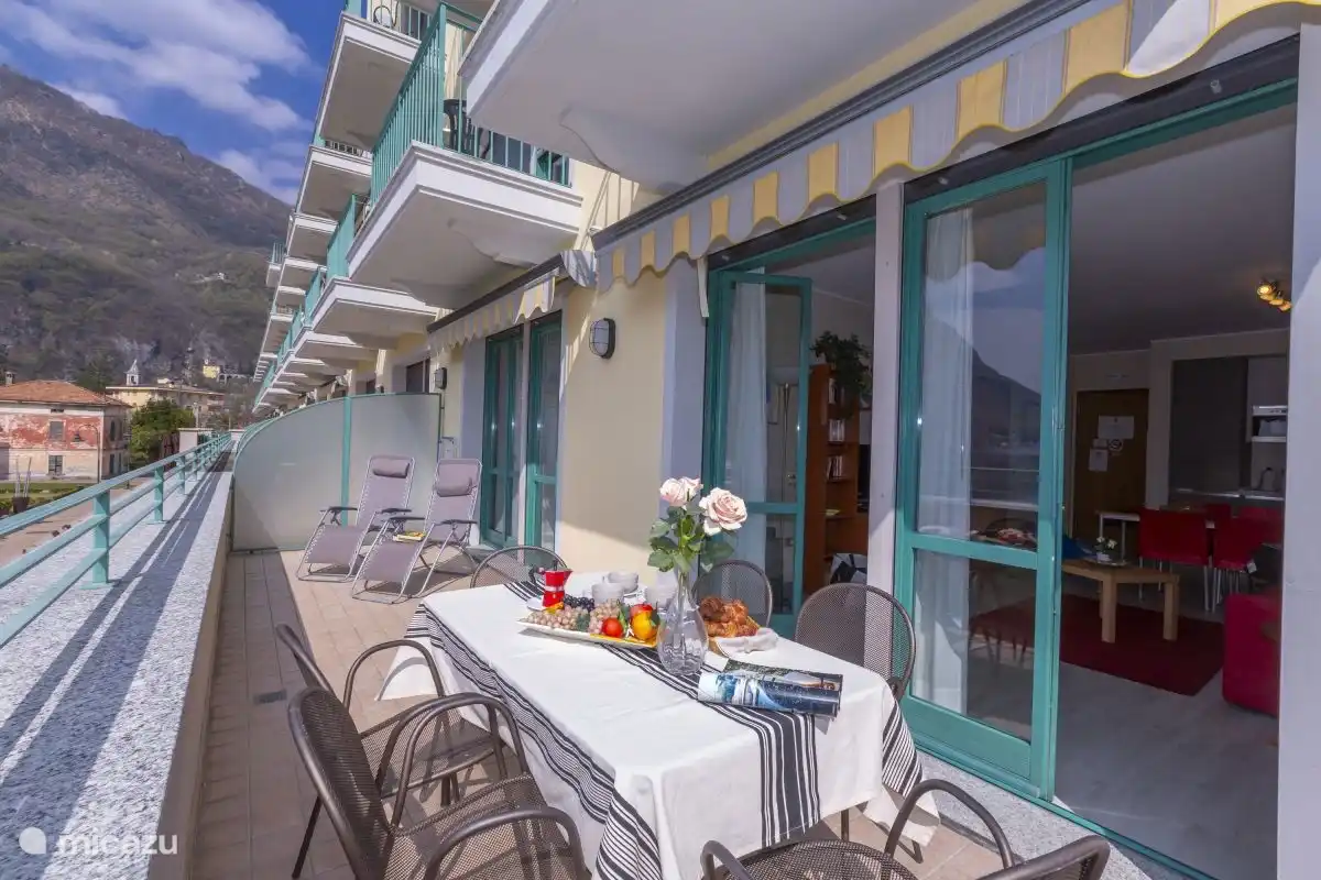 Balkon mit Sonnenliegen und Esstisch mit Stühlen für 6 Personen