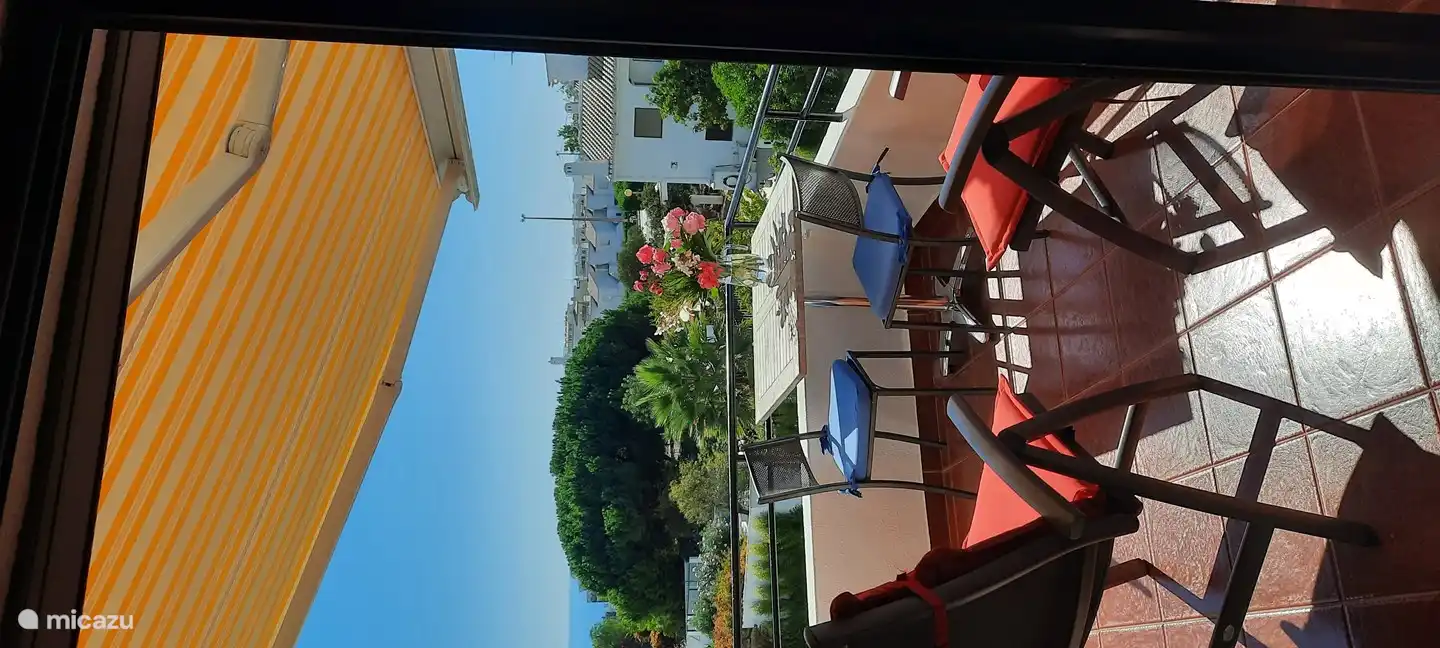 Ons terras met 2 ligstoelen en eettafel met stoeltjes en: prachtig uitzicht!
