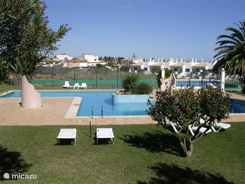 Zwembad met aansluitend kinderbad en tennisbaan op de achtergrond.