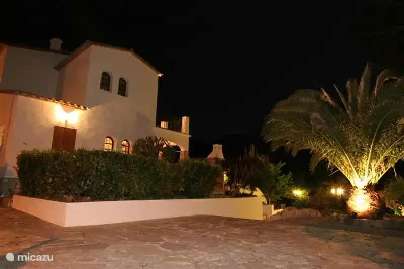 Both the house and the garden are illuminated.