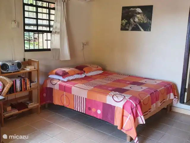 Location de Vacances Curaçao, Curaçao-Centre, Willemstad, appartement - Appartement avec piscine privée Coin séjour/chambre aménagé avec goût : lit double (2,00 mx 1,60 m), table à manger avec 2 chaises, bibliothèque, kitchenette. La chambre est équipée de moustiquaires.