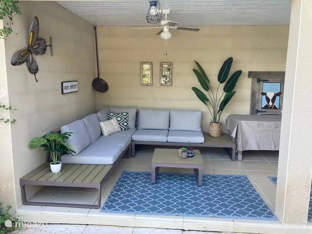 coin salon dans la cuisine extérieure avec lampe ventilateur