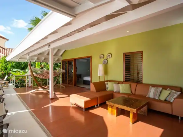 Villa frente al mar en el resort Boca Gentil en Curazao, Banda Arriba (este), Jan Thiel - villa Un amplio sofá lounge en la veranda con una hamaca resistente para 2 personas. En esta villa de vacaciones junto al mar en Curacao solo puede disfrutar en las horas de la tarde. Apto para toda la familia.