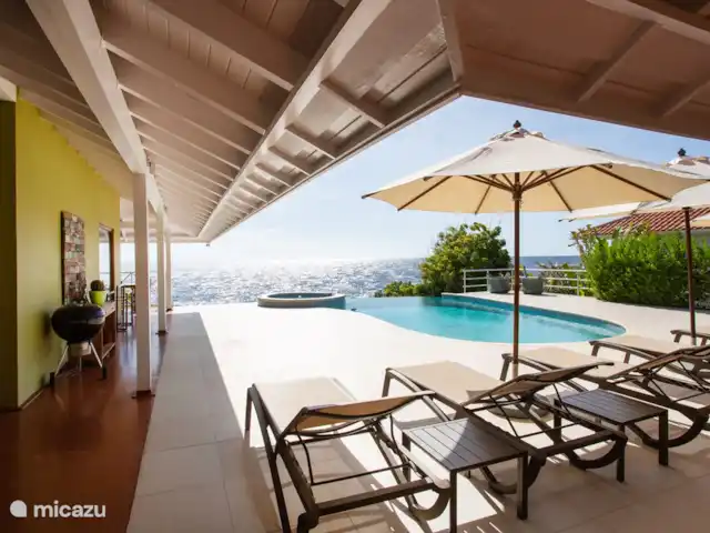 Villa frente al mar en el resort Boca Gentil en Curazao, Banda Arriba (este), Jan Thiel - villa Vista desde el salón de la villa. La amplia piscina con jacuzzi ofrece mucho espacio para relajarse en la piscina.