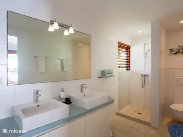 Villa frente al mar en el resort Boca Gentil en Curazao, Banda Arriba (este), Jan Thiel - villa Baño del dormitorio principal. El dormitorio principal tiene vista al mar ya la piscina. El dormitorio principal también tiene un vestidor.