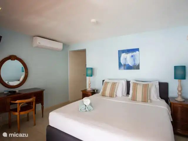 Villa frente al mar en el resort Boca Gentil en Curazao, Banda Arriba (este), Jan Thiel - villa El dormitorio principal visto desde la puerta corrediza de vidrio. Con acceso al baño.