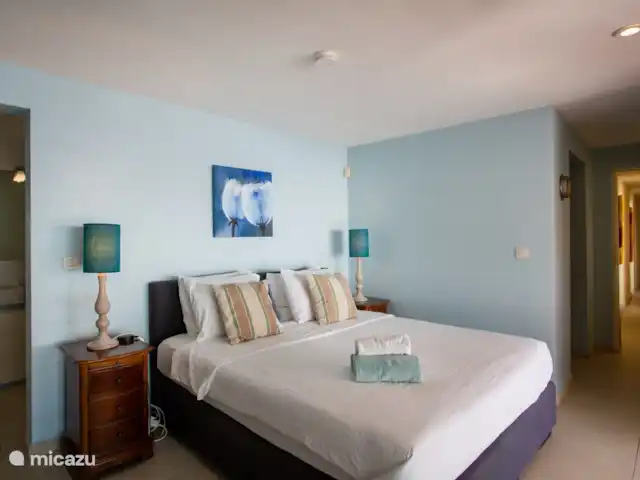 Villa frente al mar en el resort Boca Gentil en Curazao, Banda Arriba (este), Jan Thiel - villa Dormitorio principal visto desde el tocador. Aquí se ve el pasillo con las puertas de las 3 habitaciones y el aseo de invitados.