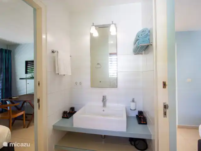 Villa frente al mar en el resort Boca Gentil en Curazao, Banda Arriba (este), Jan Thiel - villa Este es el tercer baño con vista al frente del jardín. esta vez tomada desde un ángulo diferente. Como puedes ver, en este dormitorio hay un televisor y una mesa.