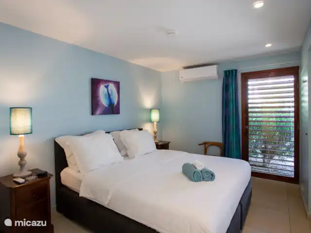 Villa frente al mar en el resort Boca Gentil en Curazao, Banda Arriba (este), Jan Thiel - villa Este es el tercer dormitorio con vista al frente del jardín. esta vez tomada desde un ángulo diferente. Como puedes ver, en este dormitorio hay un televisor y una mesa.