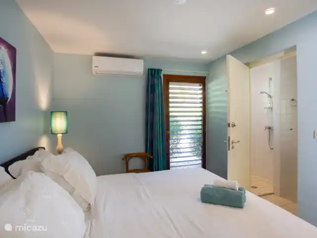 Villa frente al mar en el resort Boca Gentil en Curazao, Banda Arriba (este), Jan Thiel - villa Este es el tercer dormitorio con vista al frente del jardín. esta vez tomada desde un ángulo diferente. Como puedes ver, en este dormitorio hay un televisor y una mesa.