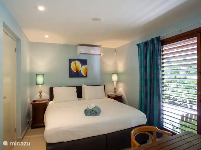 Villa frente al mar en el resort Boca Gentil en Curazao, Banda Arriba (este), Jan Thiel - villa Este es el cuarto dormitorio con vista al frente del jardín. esta vez tomada desde un ángulo diferente. Como puedes ver, en este dormitorio hay un televisor y una mesa.