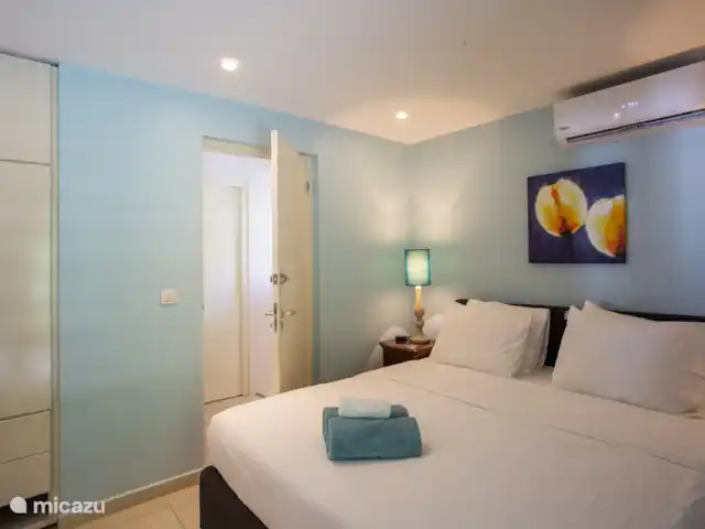 Villa frente al mar en el resort Boca Gentil en Curazao, Banda Arriba (este), Jan Thiel - villa Este es nuevamente el cuarto dormitorio con vista al frente del jardín. esta vez tomada desde un ángulo diferente. Como puedes ver, en este dormitorio hay un televisor y una mesa.