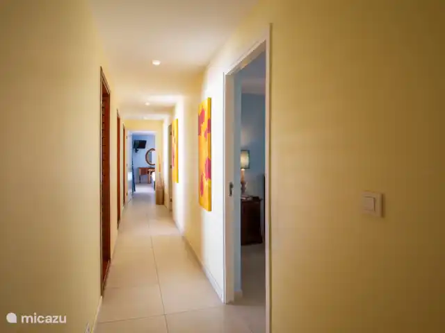 Villa frente al mar en el resort Boca Gentil en Curazao, Banda Arriba (este), Jan Thiel - villa El largo salón de la villa con los 4 dormitorios en fila. Todos los dormitorios están uno al lado del otro con los baños.