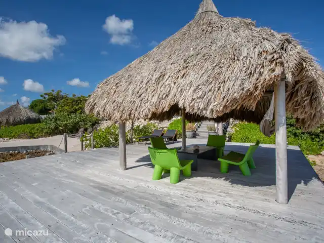 Villa frente al mar en el resort Boca Gentil en Curazao, Banda Arriba (este), Jan Thiel - villa Debajo de la gran palapa con asientos y las escaleras al mar.