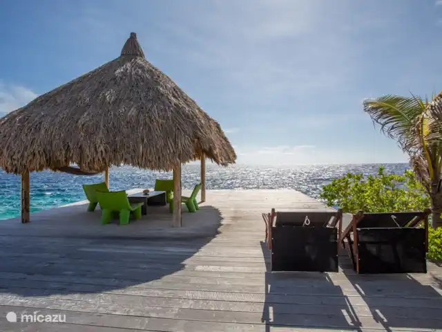 Villa frente al mar en el resort Boca Gentil en Curazao, Banda Arriba (este), Jan Thiel - villa Debajo de la gran palapa con asientos y las escaleras al mar.