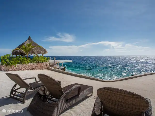 Villa frente al mar en el resort Boca Gentil en Curazao, Banda Arriba (este), Jan Thiel - villa La villa con vistas desde la gran terraza de la piscina. Ves la palapa con la terraza flotante en el mar.