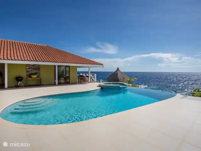 Villa frente al mar en el resort Boca Gentil en Curazao, Banda Arriba (este), Jan Thiel - villa La villa con vistas desde los dormitorios con la gran terraza de la piscina. Puedes ver el jacuzzi y la hermosa piscina infinita ovalada.