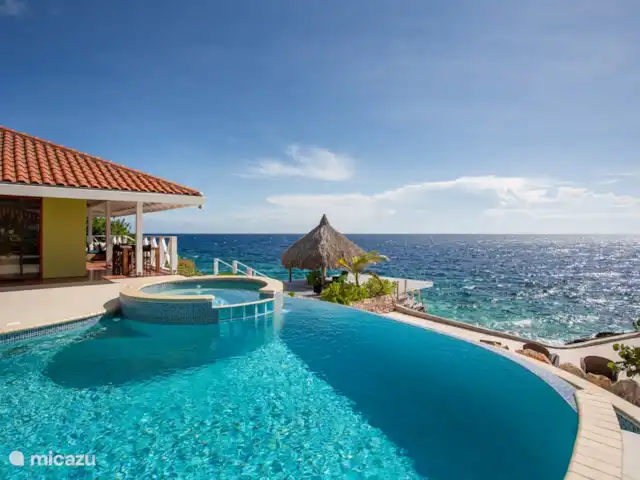 Villa frente al mar en el resort Boca Gentil en Curazao, Banda Arriba (este), Jan Thiel - villa Piscina infinita ovalada con jacuzzi para 8 personas. Con vista de 180 grados al mar y Willemstad.