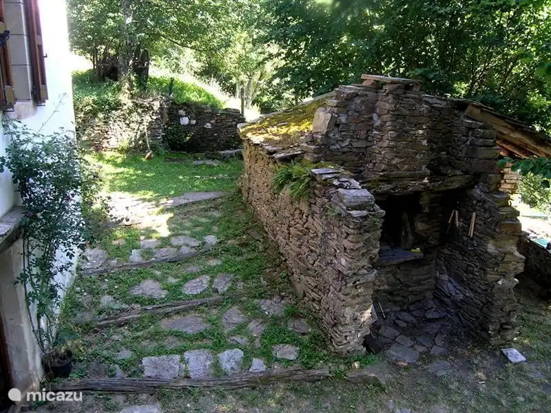 Mira a través del antiguo horno de pan en el que también puedes hornear pizza y barbacoa.