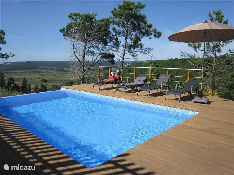 The heated swimming pool with sun loungers and stunning views